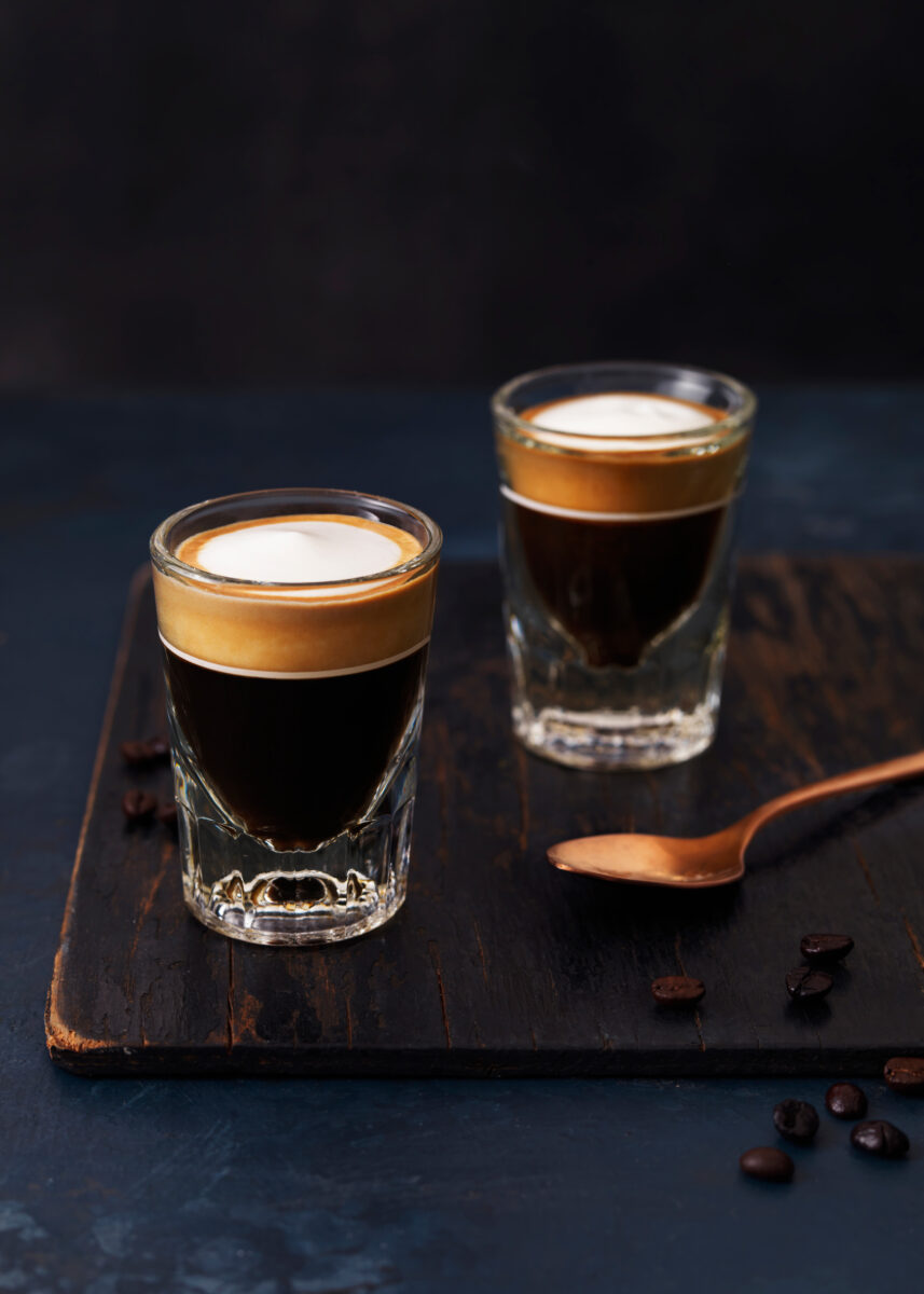 two shots of macchiato on dark background with spoon and sugar drink photographer fotograf drinkov london bratislava